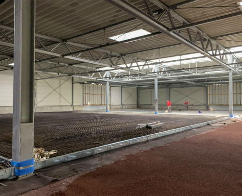 Innenansicht der Produktionshalle während der Bauphase mit Stahltragwerk und vorbereiteter Bodenbewehrung bei Wagner Fahrzeugteile