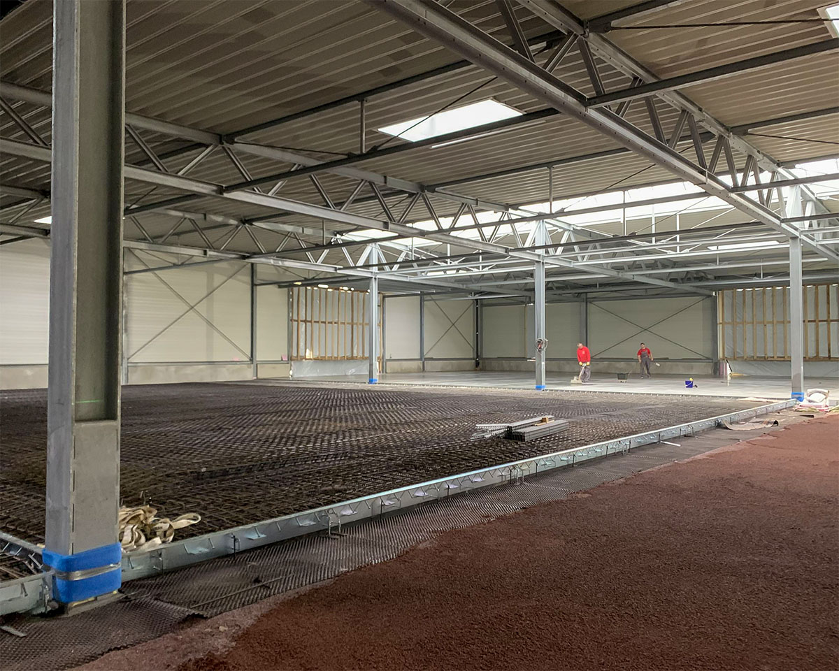 Innenansicht der Produktionshalle während der Bauphase mit Stahltragwerk und vorbereiteter Bodenbewehrung bei Wagner Fahrzeugteile