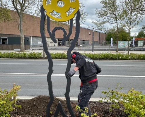 Aufbau einer der Stahlfiguren in einem Beet an der Sport- und Erlebnismeile in Dortmund