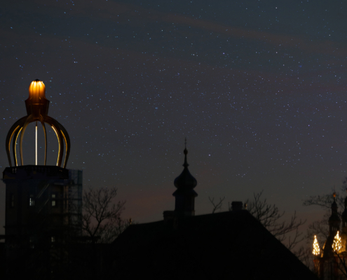 Die beleuchtete Turmhaube des Stadtschloss Fulda bei Nacht vor Sternenhimmel
