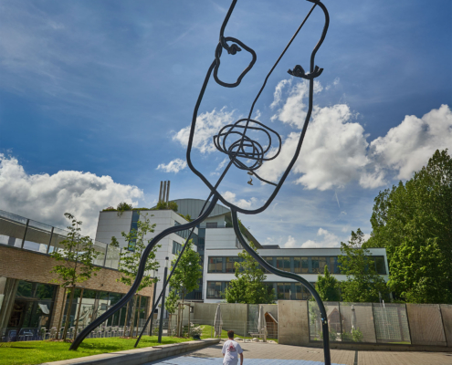 Die Skulptur "I See A Face. Do You See A Face" von Flaka Haliti mit einem Skateboarder davor fahrend